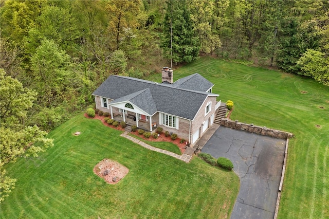 aerial view of property and surrounding area featuring a heavily wooded area