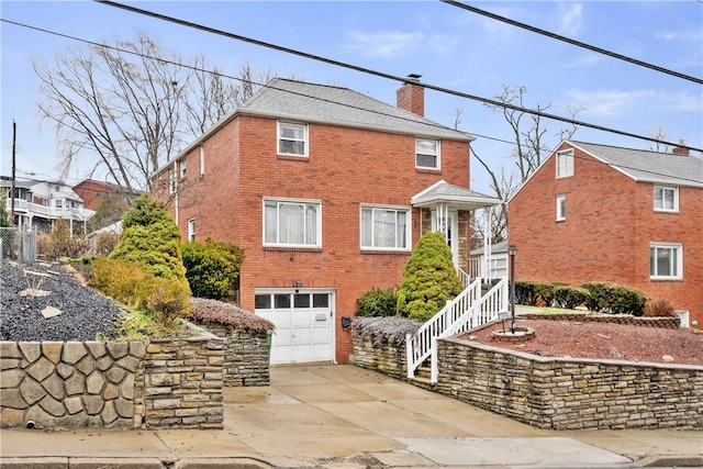 1009 Connor Rd, Castle Shannon, PA 15234 - traditional home with a garage, a chimney, driveway, and brick siding