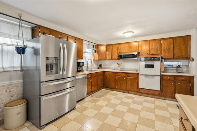 1009 Connor Rd, Castle Shannon, PA 15234 - kitchen featuring stainless steel appliances, brown cabinetry, a sink, and light countertops