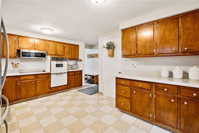 1009 Connor Rd, Castle Shannon, PA 15234 - kitchen featuring stainless steel microwave, double oven, light countertops, and brown cabinetry