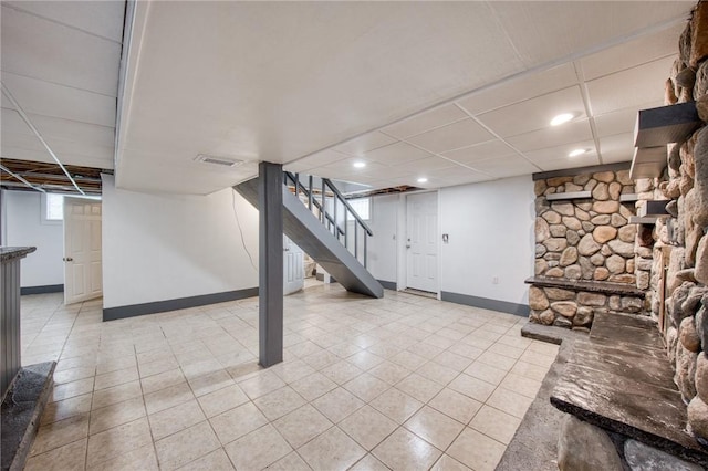 below grade area featuring stairs, light tile patterned floors, baseboards, and recessed lighting