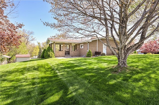 back of property with a yard and brick siding