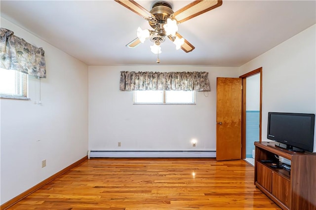 unfurnished bedroom featuring baseboard heating, light wood finished floors, baseboards, and a ceiling fan