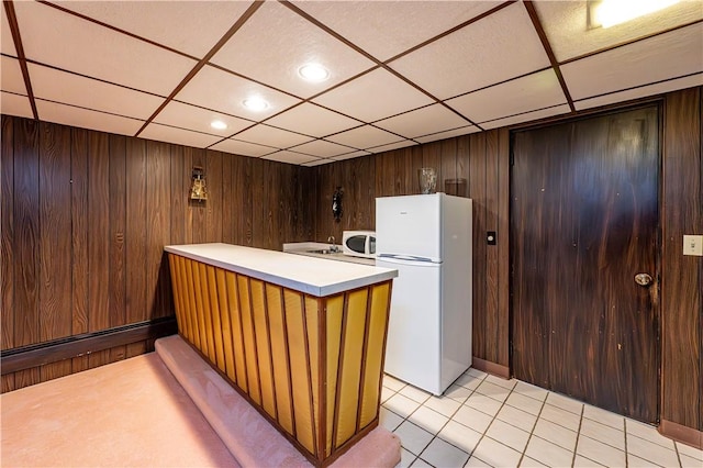 reception with a drop ceiling, wooden walls, and recessed lighting