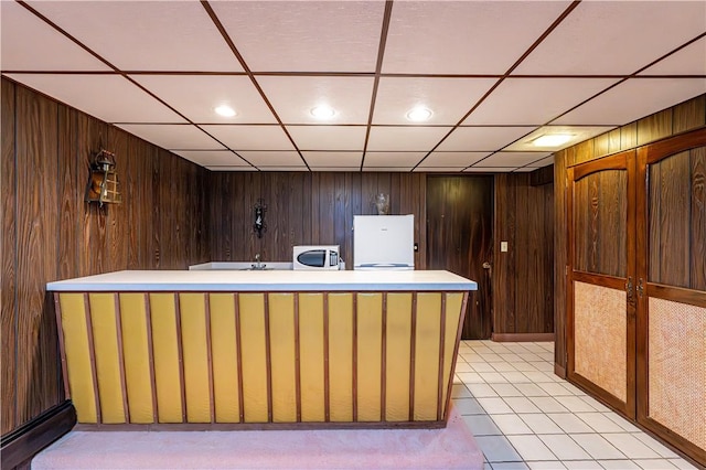 reception area featuring wooden walls and a paneled ceiling