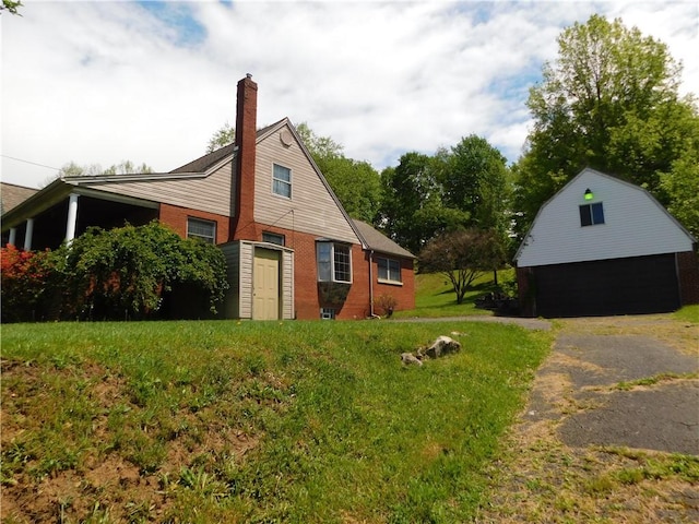 110 Holbert Stretch Rd, Bobtown/Dilliner, PA 15327 - view of property exterior with a garage, a chimney, an outbuilding, brick siding, and a lawn