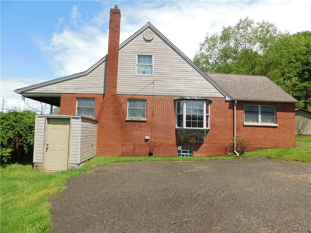 110 Holbert Stretch Rd, Bobtown/Dilliner, PA 15327 - rear view of house featuring brick siding, a chimney, a shed, a shingled roof, and an outdoor structure