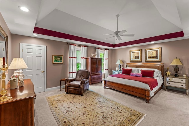 bedroom featuring carpet, a tray ceiling, recessed lighting, baseboards, and a ceiling fan