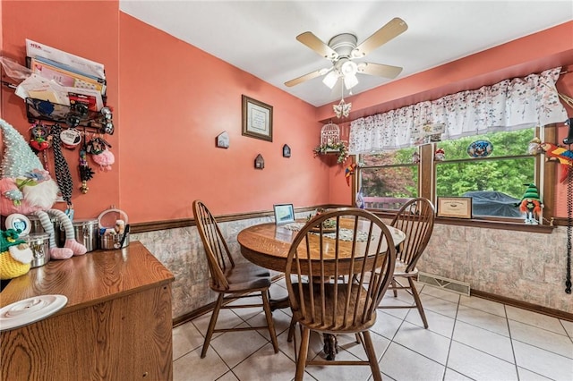 620 Sandy Hill Rd, Manor, PA 15642 - dining area featuring a wainscoted wall, ceiling fan, and light tile patterned floors