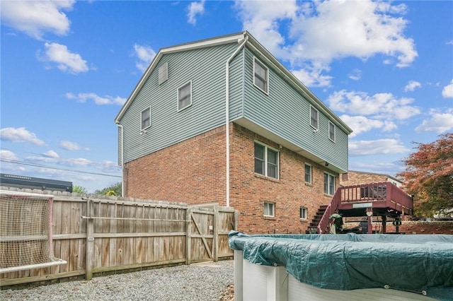 620 Sandy Hill Rd, Manor, PA 15642 - back of house with brick siding, a wooden deck, fence, stairs, and a gate