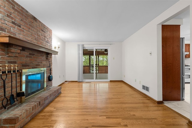 2023 Menold Dr, Mccandless, PA 15101 - unfurnished living room featuring light wood finished floors, a brick fireplace, a ceiling fan, and baseboards