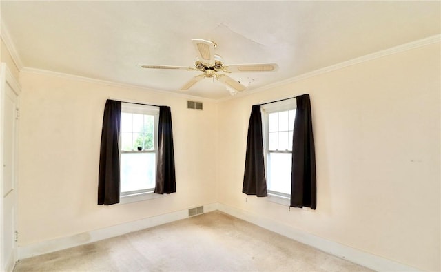 unfurnished room featuring ornamental molding, baseboards, plenty of natural light, a ceiling fan, and light colored carpet