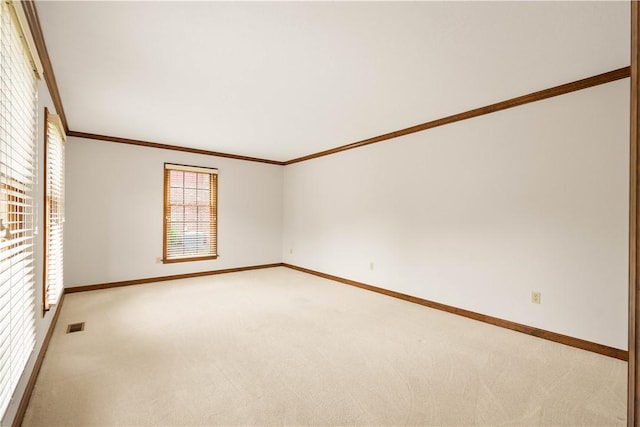 carpeted empty room with baseboards and crown molding