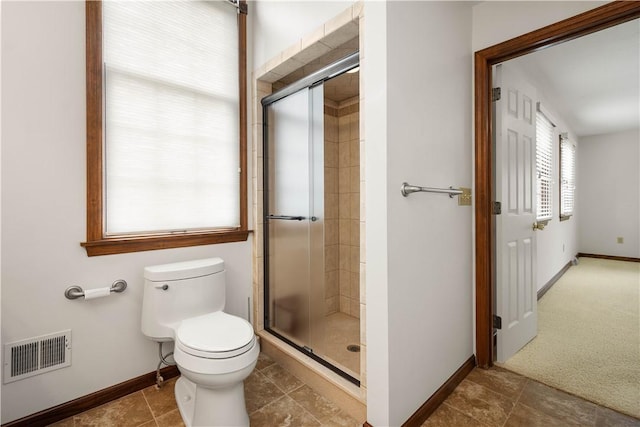 full bathroom featuring a shower stall, toilet, and baseboards