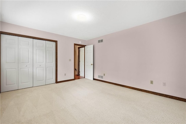 unfurnished bedroom with carpet, baseboards, and a closet