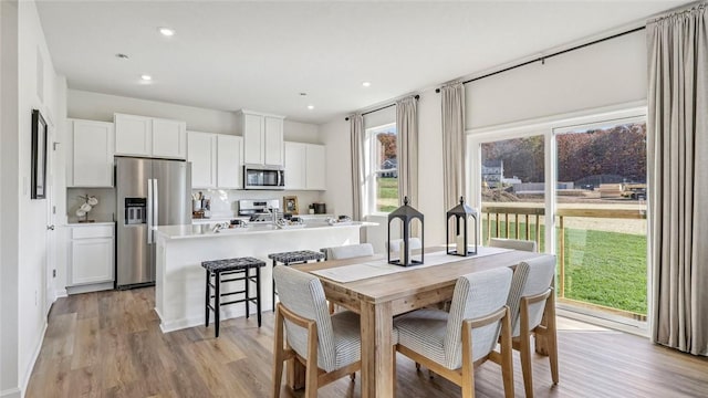 dining room with light wood-style floors and recessed lighting