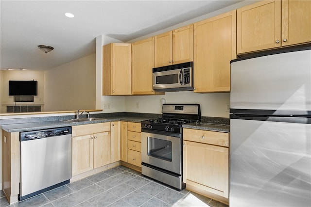 kitchen featuring appliances with stainless steel finishes, light brown cabinets, a sink, light tile patterned flooring, and open floor plan
