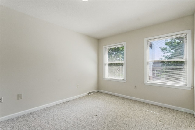 empty room with light carpet, plenty of natural light, and baseboards