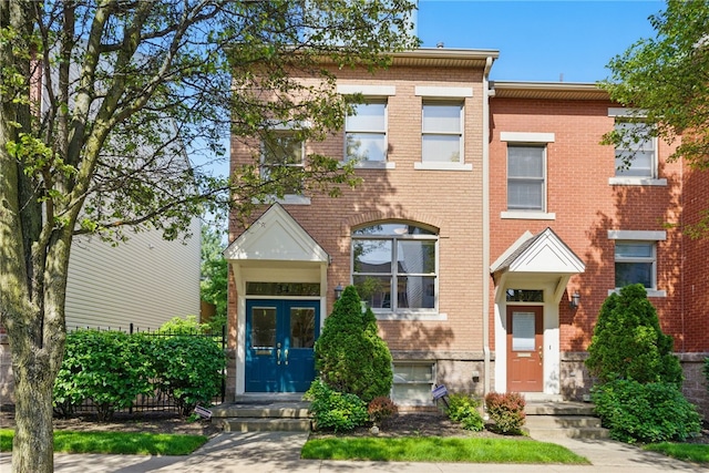 view of front of property featuring brick siding and french doors