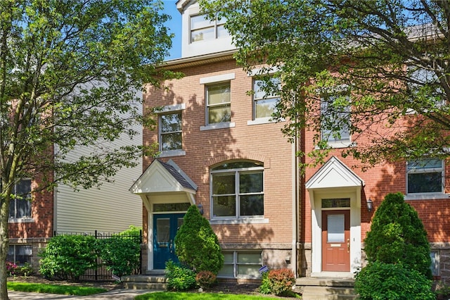 townhome / multi-family property with brick siding and fence