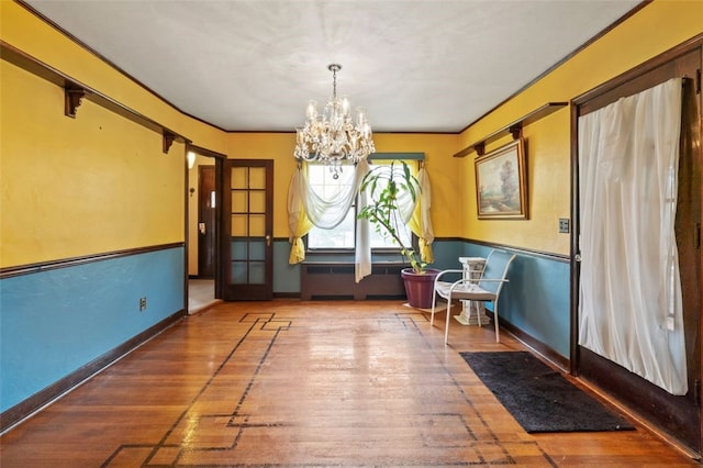 dining space featuring a chandelier, wood-type flooring, radiator, and baseboards