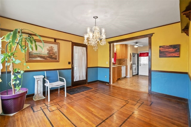 dining room with a chandelier, wood finished floors, baseboards, and a ceiling fan
