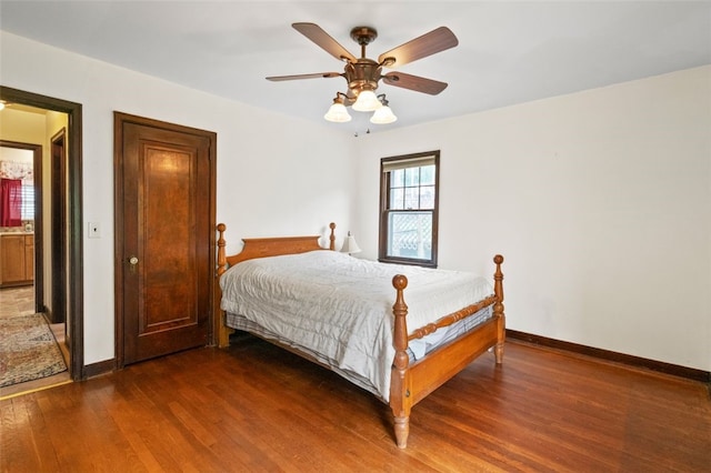 bedroom with dark wood-style floors, baseboards, and a ceiling fan