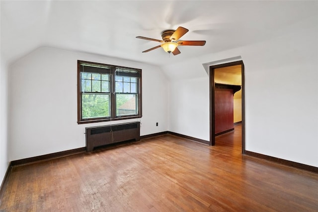 additional living space featuring radiator heating unit, vaulted ceiling, ceiling fan, wood finished floors, and baseboards