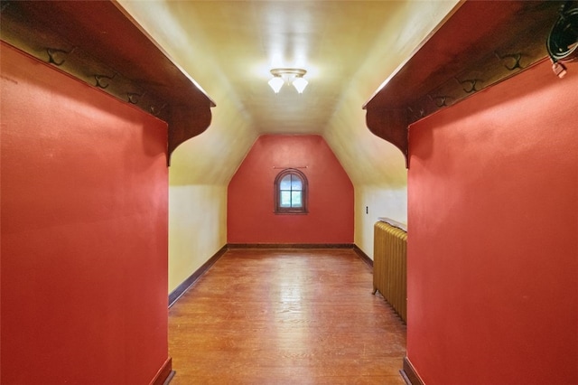 bonus room featuring wood finished floors and vaulted ceiling