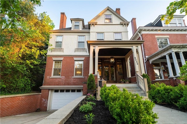 6020 Grafton St, Highland Park, PA 15206 - view of front of home with french doors, driveway, a garage, and a chimney