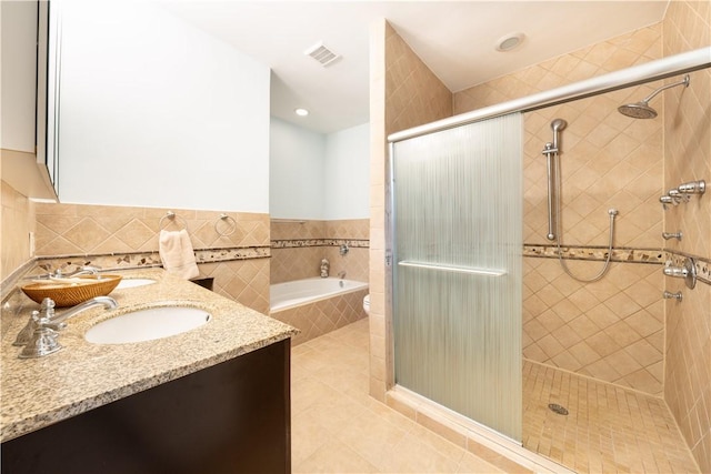 6020 Grafton St, Highland Park, PA 15206 - full bathroom featuring a stall shower, a bath, double vanity, tile patterned flooring, and tile walls