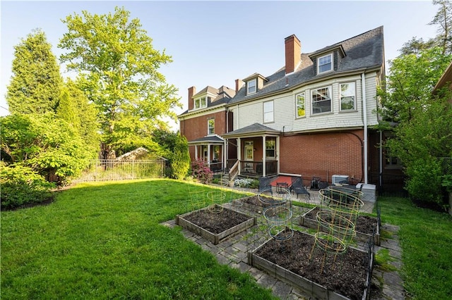 6020 Grafton St, Highland Park, PA 15206 - back of house with a vegetable garden, brick siding, and a chimney