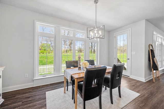 dining area featuring a chandelier, baseboards, and dark wood-type flooring