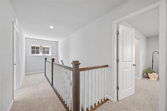 corridor featuring light colored carpet, baseboards, an upstairs landing, and recessed lighting