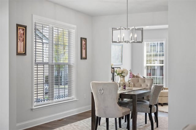 dining area with a chandelier, baseboards, and wood finished floors