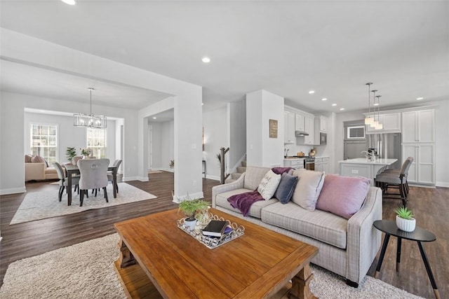 living area with stairs, dark wood finished floors, baseboards, recessed lighting, and a chandelier