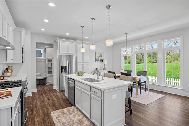 kitchen featuring a sink, stainless steel appliances, a chandelier, a kitchen breakfast bar, and recessed lighting