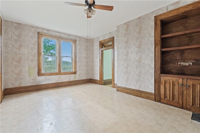 empty room featuring tile patterned floors, ceiling fan, and baseboards