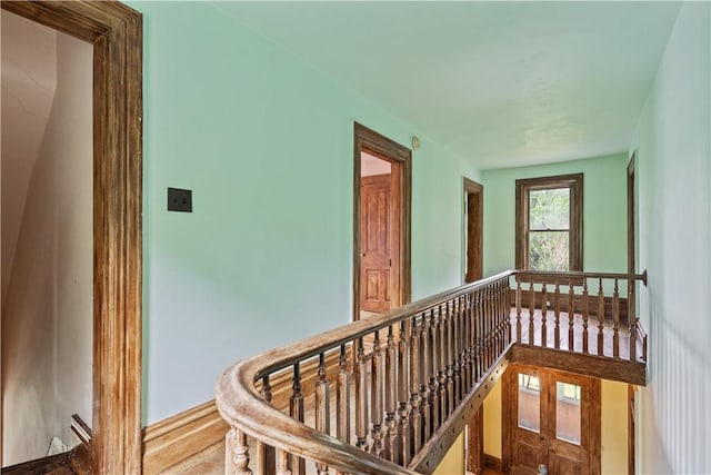 hall with an upstairs landing and wood finished floors