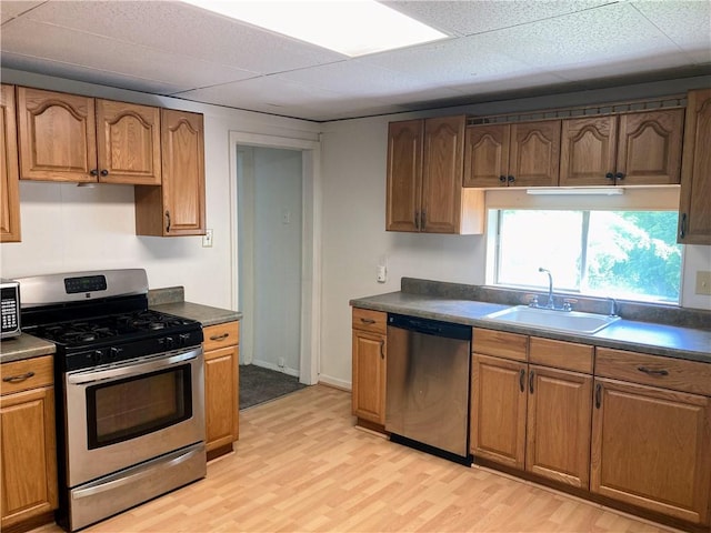 4974 Williamsport Rd, Elizabeth Twp/Boro, PA 15037 - kitchen featuring appliances with stainless steel finishes, a sink, light wood-type flooring, dark countertops, and a paneled ceiling