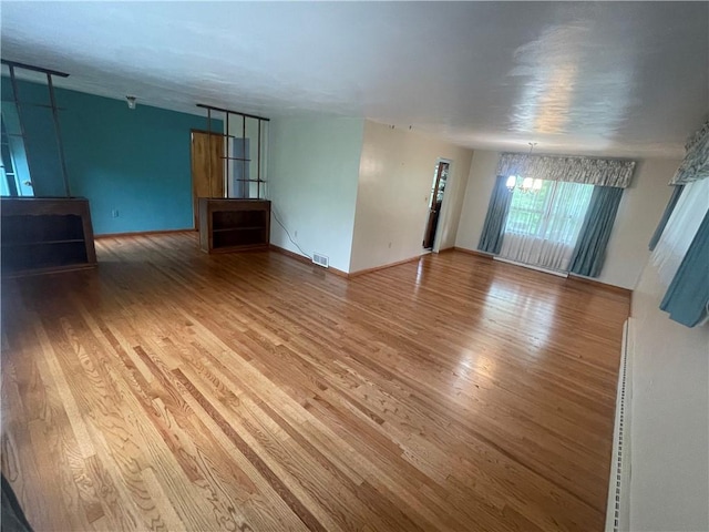 107 Pfaff Rd, Economy, PA 15005 - unfurnished living room with wood finished floors, baseboards, and a chandelier