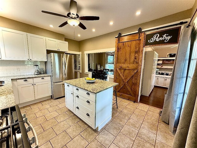 1701PLEASANT Pleasant, West Mifflin, PA 15122 - kitchen featuring freestanding refrigerator, a ceiling fan, light stone counters, decorative backsplash, and white cabinetry