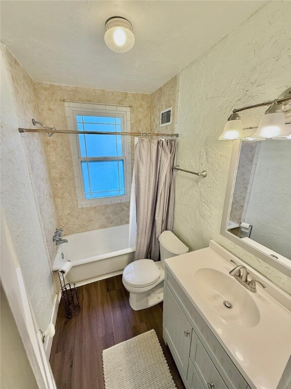 1701PLEASANT Pleasant, West Mifflin, PA 15122 - bathroom with a textured wall, wood finished floors, toilet, shower / bathtub combination with curtain, and vanity