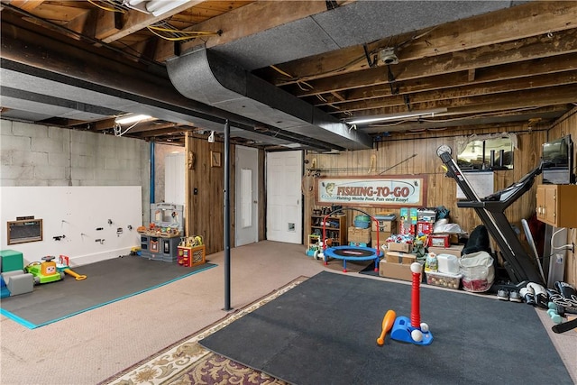 unfinished basement with wood walls and carpet floors