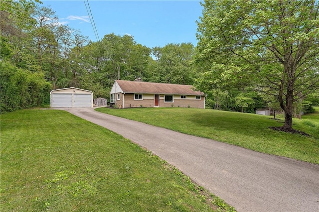 single story home with an outdoor structure, a detached garage, a front lawn, and a chimney