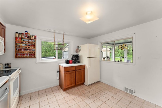 kitchen featuring white appliances, light countertops, baseboards, and brown cabinets