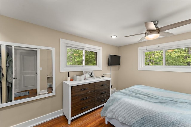 bedroom featuring wood finished floors, baseboards, and a ceiling fan