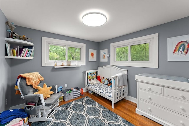 bedroom with wood finished floors and baseboards