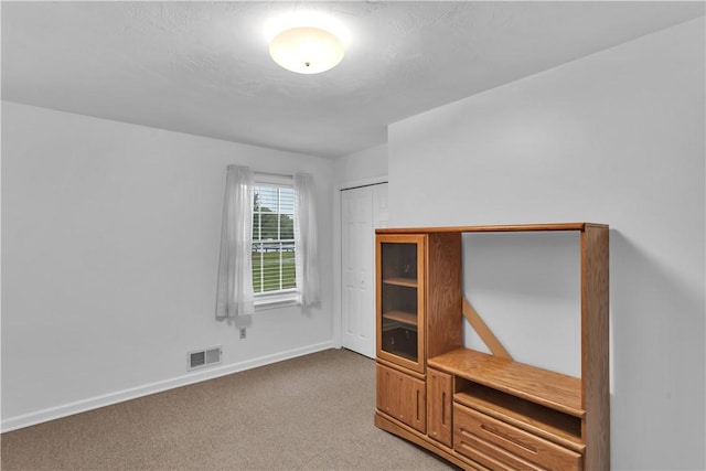 unfurnished bedroom with baseboards and light colored carpet