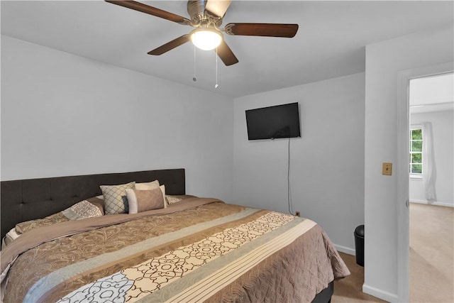 bedroom with light carpet, ceiling fan, and baseboards